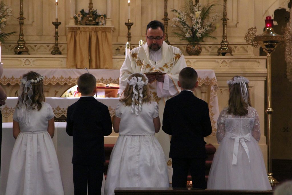 First Communion Children receive blessing on the Altar